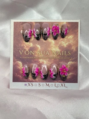 Yara (XS);Medium Almond - Unika handgjorda press-on naglar i medium almond med nude bas, svart spetsinspirerad french och handgjorda 3D-blommor i starka rosa och lila toner. Dekorerade med handmålade leoparddetaljer och gulddetaljer för en exklusiv finish. Perfekt för dig som vill bära en unik design som sticker ut. XS: 14 mm, 11 mm, 11,5 mm, 10 mm, 8 mm