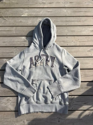 Vintage Abercrombie And Fitch Hoodie - Säljer nu denna Abercrombie and fitch hoodie med sjukt snygga slitningar! Den har en liten fläck på ärmen men detta är inget som syns vid användning. Hör av dig vid frågor :)