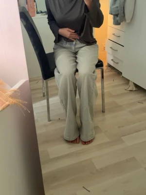 Ljusgråa raka jeans med hög midja - Säljer ett par ljusgråa jeans med rak passform och hög midja. Jeansen har klassisk femficksdesign och långa ben som faller snyggt över fötterna. Perfekta för en avslappnad och trendig look.