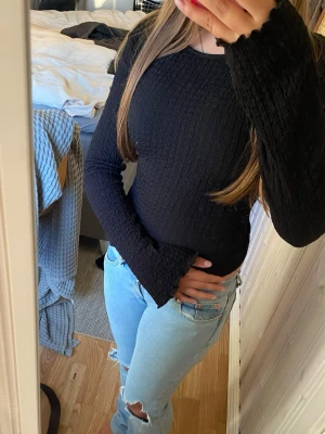 Svart våfflad långärmad topp - Svart våfflad långärmad topp med utsvängda ärmar från Lager 157. Toppen är för stor för mig och bilderna är anpassade efter min storlek så passformen kan variera litegrann. Jag har i vanliga fall Xs eller S. Det är även ett otroligt stretchigt material. Skriv till mig vid funderingar💞