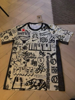 Mexico tröja – Ny med tags -   Säljer en Mexico-tröja i svart/vit design med stilrent tryck inspirerat av Kalifornien och streetwear. Helt ny med tags kvar. Bekväm och perfekt för både träning och vardag.  