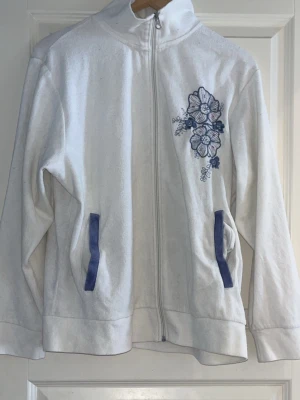 Vit Livtröja med brodering blå lila blommor paljetter från Åshild - Vit Livtröja med brodering blå lila blommor paljetter från Åshild. Köpt second hand. 🚨Tar bara emot betalningar via Swish!!! Om du vill ha fler bilder eller har frågor är det bara att skriva till mig!!!🚨