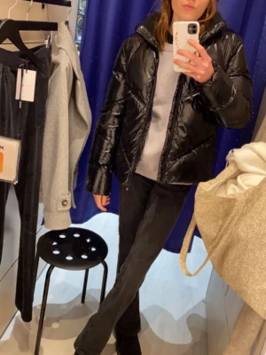 Svart pufferjacka från Calvin Klein - Säljer en svart, glansig pufferjacka från Calvin Klein med huva och dragkedja framtill storlek 170cm/ S. Jackan har quiltade sömmar och en liten CK-logga på ärmen. Perfekt för kalla dagar och riktigt snygg till både jeans och mjukisbyxor. Ny pris var 1999kr men säljer den nu för 800kr trots att den är använd ett fåtal gånger 