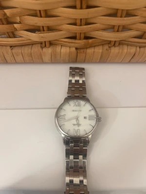 Klassisk silverklocka från Gant - Stilren klocka från Gant med silverfärgad länk och vit urtavla. Klockan har romerska siffror och datumvisning. Perfekt accessoar för dig som gillar en tidlös och elegant look. Men batterit måste ändras o h de kostar max 100 kr men de kan jag gör om någon är intresserad 