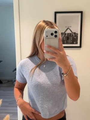 Ljusblå stickad croppad topp - Ljusblå stickad cropped T-shirt 💙 Superfin och aldrig använd! Croppad modell som går ungefär till magen. Storlek/märke okänt då lappen är borttagen.