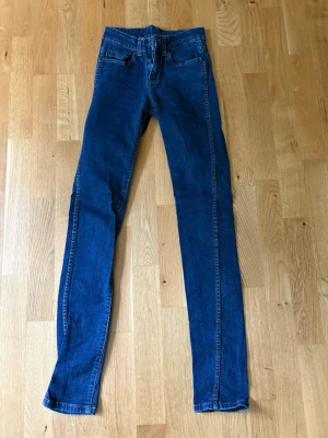 Mörkblå skinny jeans med hög midja - Säljer ett par mörkblå skinny jeans med hög midja och klassiska fem fickor. Perfekta för dig som gillar klassiska dr demin. Stretchjeans som sitter bekvämt ✨storlek 24/32 