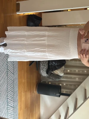 Vit långkjol - Säljer en vit lång kjol med rak passform och enkel, stilren design. jag är 175 cm