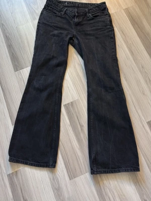 Svarta bootcut jeans - Säljer ett par svarta bootcut lowwaist jeans från Weekday i stl S/M. Jeansen har en snygg tvättad look och är tillverkade i denim. Passar perfekt till dig som gillar en avslappnad men trendig stil. Inga defekter förutom lite ”rivigt” längst nere (se bild 4) men absolut inget man tänker på. Bara att höra av dig vid frågor eller fler bilder❤️