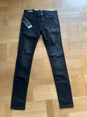 Svarta jeans från Jack & Jones - Svarta jeans från Jack & Jones med passformen Spray on/ Tom och storlek W30L32