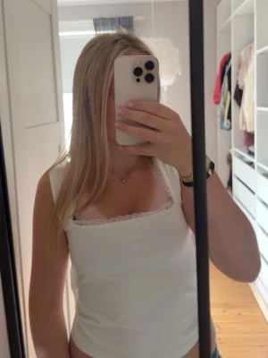 Vit linnetopp med spets och knyt - Säljer en söt vit linnetopp med spetsdetaljer längs urringningen och knyt i ryggen från Gina 14+💕