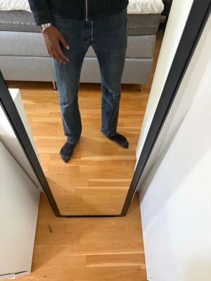 Blå raka jeans herr Levis 501 - Säljer ett par klassiska blå jeans med rak passform. Jeansen har normal midja och är tillverkade i denim med en mörk tonig look. Perfekta till vardags och passar till det mesta. Jag är 194 cm lång och byxorna är en aning för korta för mig. Ordinarie pris 1499. 
