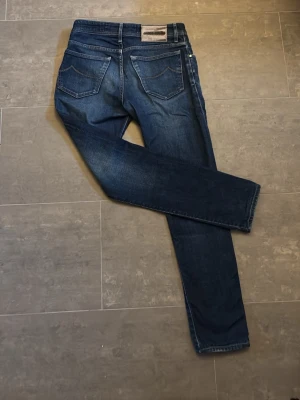 Mörkblå raka jeans - Säljer ett par mörkblå jacob Cohen jeans med raka ben och klassisk femficksmodell. . Materialet är denim i bomull.