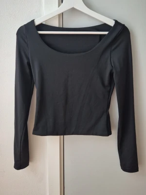 Svart långärmad topp med rund hals - En stilren svart långärmad topp med rundad urringning och figurnära passform. Perfekt att matcha med jeans eller kjol för en enkel och snygg look. Tillverkad i mjukt material som känns skönt mot huden. Köpt på Shein. Storlek XS. Lappen avklippt. 