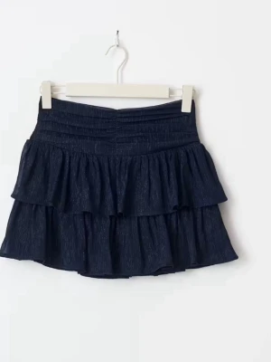 Mörkblå volangkjol - Snygg mörkblå kjol med volanger. Kjolen har två lager volanger som ger en cool och lekfull look. Perfekt att matcha med en crop top eller stickad tröja för en trendig outfit.