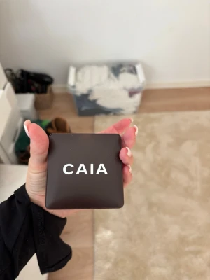 CAIA bronzer tuscay  - Snygg bronzer från CAIA i en stilren, fyrkantig brun kompakt med spegel. Perfekt för att framhäva ansiktskonturer och skapa glow. Smidig att ta med i väskan. Använd några gånger men passar inte i färgen 