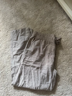 Beige linnebyxor från Livergy - Snygga beige linnebyxor från Livergy med avslappnad passform och dragsko i midjan. Perfekta för en chill och stilren look. Tillverkade i ett lätt och luftigt linnematerial som passar bra till varmare dagar.