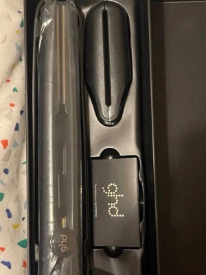 ghd gold plattång svart - Säljer en svart ghd gold plattång med tillhörande värmeskydd och originalförpackning. Plattången har en stilren design med rundade kanter och lång sladd för smidig användning. Perfekt för att styla håret rakt eller lockigt.