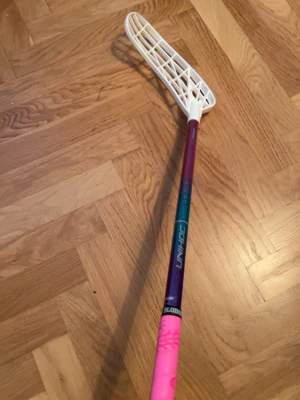 Unihoc MID DLX 29 - Säljer en snygg innebandy klubba från Unihoc i skaftlängd 87cm. Klubban är fåtal gånger använd. Klubban kommer med en rosa klubbhuset Linda helt ny. Bladet är ett unilite blad med böj som man ser på bild.