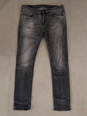 DONDUP Jeans - Snygg mörkgrå tvätt av populära märket Dondup, ett etablerat märkw inom gruschkulturen och säljs vanligtvis dyrt i andrahand. Varan har tydligen tecken på användning men har anvönts av mig i detta skick och slitagen sitter på tacksamma ställen och har inte påverkat upplevelsen.