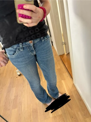Blå bootcut jeans med kontrastsömmar - Pris kan alltid diskuteras!Säljer ett par ljusblå bootcut jeans med vita kontrastsömmar .Jeansen har låg midja. Materialet är denim i bomull och passformen är figurnära upptill med utsvängda ben.