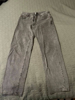 Grå raka jeans från woodbird - Säljer ett par gråa raka jeans från woodbird i modellen 'Grey Ash'. Jeansen har klassisk femficksdesign, normal midja och är tillverkade i ett slitstarkt denimtyg. Perfekta för en avslappnad och trendig look.