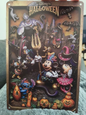 Disney Halloween metallskylt - Cool metallskylt med Disney Halloween-motiv. Skylten har färgglada illustrationer av Mickey, Minnie, Stitch och flera klassiska Disney-karaktärer i halloweenkostymer, samt pumpor och slott i bakgrunden. Perfekt som dekoration till halloween eller för Disneyfans.