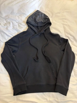 Syna world hoodie - Säljer en svart syna world hoodie som knappt är använd. snöret åkte av i tvätten men det går att lösa med nål enkelt.