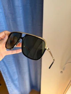 Gucci solglasögon  - Stilrena solglasögon med guldiga detaljer från Gucci. De är använda men fortfarande i bra skick, mindre tecken på användning finns, se bilder! Orginal fodral, rengörningsservett samt dustbag medföljer! Hör av er vid intresse eller vid önskan om fler bilder!