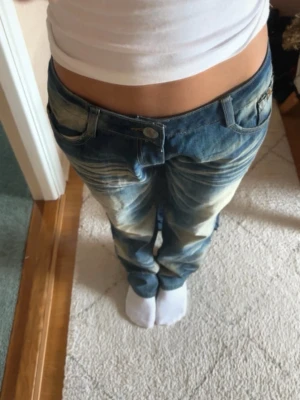 Blå jeans - Ett par blå jeans med  ljusa tvättade partier framtill. 