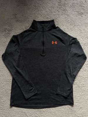 Under Armour 1/4 Zip - Skön Slim fit Under Armour tröja, väldigt trevlig passform. För mer bilder eller frågor är det bara att skriva!