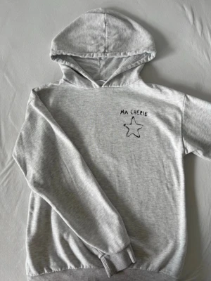 grå hoodie 158/164 - Grå hoodie i storlek 158/164. Använd men i fint skick. Superbekväm och har ett gulligt tryck fram och bak. Snörena till huvan finns tyvärr inte kvar. 🌟