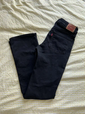 Superlow bootcut Levi’s - Snygga svarta/mörkgråa jeans från Levi's med bootcut-passform och klassiska fem fickor. Jeansen är lågmidjade och är i storlek w26 L34. 