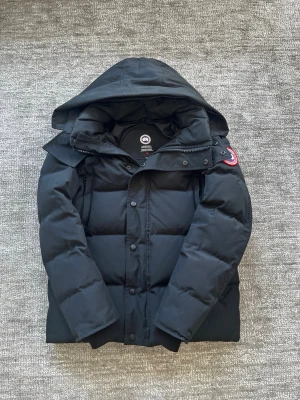 Svart Canada Goose jacka - Svart canada goose jacka i storlek S. Knappt använd. Inget fel eller slitet på den. Passar 176-186, ca 60-80kg. Precis som ny. Hör av vid frågor. Påsen till jackan ingår såklart! Priset kan diskuteras vid snabb affär