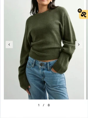 Olivgrön stickad tröja - Mysig olivgrön stickad tröja med rund halsringning och långa ärmar. Tröjan har en rak passform och ribbstickade muddar vid ärmslut och nederkant. Perfekt att matcha med jeans för en avslappnad look.