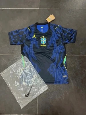 Blå Brasilien fotbollströja Nike - Snygg blå och svart Brasilien fotbollströja från Nike med gula detaljer och landslagets emblem på bröstet. Tröjan har korta ärmar, rund hals och är tillverkad i ett lätt, ventilerande material som passar perfekt till träning eller match.