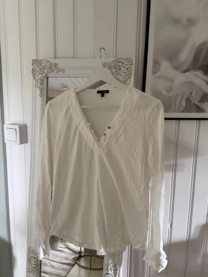 Vit långärmad Massimo Dutti🤍 - Stilren vit långärmad från Massimo Dutti med v-ringning och dekorativa knappar framtill. Enkel och klassisk design som är lätt att matcha med andra kläder eller att ha under en stickad tröja😇👏🏼