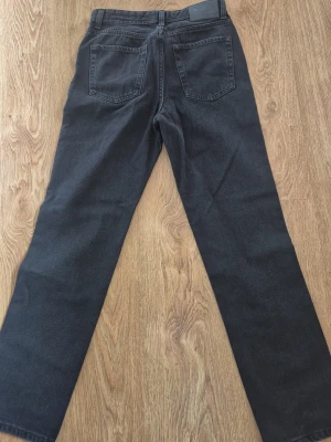 Svarta raka jeans från Jack & Jones - Säljer ett par helt nya svarta jeans från Jack & Jones i rak modell. Jeansen har klassiska bakfickor och bälteshällor. Materialet är denim i bomull och de passar perfekt för en avslappnad och stilren look.