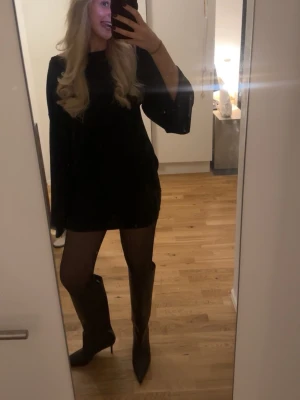 Svart kort klänning med vida ärmar - Snygg svart kort klänning med långa, vida ärmar och enkel, rak passform. Klänningen är stilren och passar perfekt till boots eller sneakers. Klänningen är i bra skick !