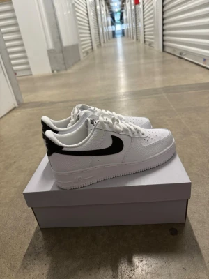 Nike Air Force 1 '07 Vit/Svart strl 44 - Helt nya oanvända Nike Air Force 1 '07 Vit/Svart strl 44. Skorna har inte blivit använda eller testade.  Original kartong medföljer. Nypris hos Nike 1400 kr.