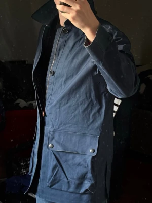 Fieldjacket från Polo Ralph Lauren - Säljer en sjukt fet regnrock/fieldjacket från Ralph Lauren 🍁 Jackan är mörkblå, storlek M och i mycket fint skick. Dragkedja och detaljerade knappar med flera fickor och knappar för att justera midjan. Funkar perfekt för höstdagar och den slaskiga vintern   Tveka inte att höra av dig vid minsta fråga eller fundering 🙌🙏