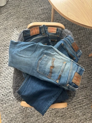 Nudie jeans bulk! - Säljer flera par klassiska blå jeans från Nudie Jeans i olika tvättar. Jeansen har raka ben, fem fickor och detaljerade sömmar på bakfickorna. Perfekta för dig som gillar en avslappnad och tidlös stil.