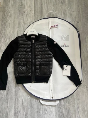 Moncler cardigan dam - Hejsan. En Moncler cardigan till salu. Jag har andvänt den väldigt sparsamt och lite. Jag säljer den pågrund av att den inte andvänds så mycket. Den är äkta och köpt på Moncler hemsida digitala kvittot finns kvar. Den är väldigt fin och passar de flesta 160/170cm. Den har inga defekter eller spår av andvändning. Hör av dig vid frågor! 💞