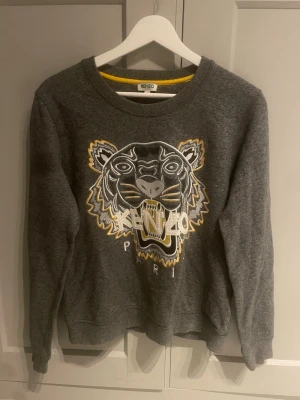 Klassisk Grå Kenzo Paris tröja  - Grå Keno Paris Sweatshirt. Väldigt fint skick. Storlek L i damstorlek. Pris:149 kr
