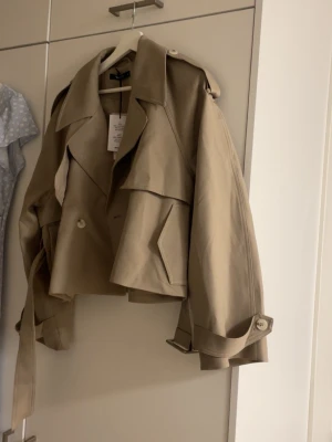 short belted trench coat - Super fin, helt oanvänd, köpt för 799:95 på Gina. Prislappen finns kvar 