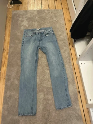 Ljusblå raka jeans från 157 - Säljer ett par ljusblå jeans från 157 med rak passform och klassisk femficksdesign. Jeansen har normal midja och är tillverkade i ett slitstarkt denimtyg. Perfekta för en avslappnad och trendig look.