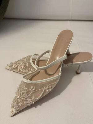Vita spetsiga pumps med pärlor - Eleganta pumps i vitt med spetsig tå och låg klack. 