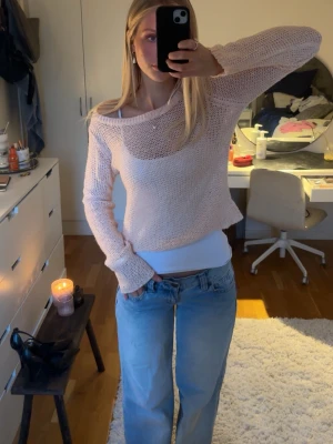 Ljusrosa meshstickad tröja - Trendig ljusrosa meshstickad tröja med lös passform och bred halsringning. Tröjan har långa ärmar och är tillverkad i ett tunt, luftigt material som ger en avslappnad vibe. Perfekt att styla över ett linne eller topp för en cool lager-på-lager-look. Bilden är från hon jag köpte tröjan av!!🫶🏻