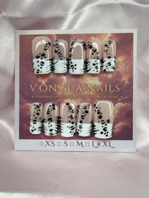 WildThing (XL);Medium Square - Snygga handgjorda och unika press-on naglar i storlek XL: 17 mm, 13 mm, 14 mm, 12 mm, 11 mm, med fransk tipp i vitt och svart leopard/tigermönster. Naglarna har en nude bas och är handgjorda för en unik look. Perfekt för dig som vill ha trendiga och djurinspirerade naglar.