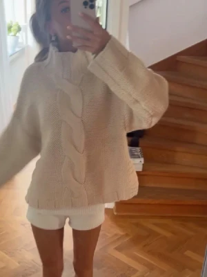 Beige kabelstickad tröja - Säljer denna mysiga beigea stickade tröjan med grovt kabelmönster framtill och hög krage!!!🩷🩷endast testad