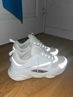 Chunky vita sneakers med meshdetaljer - Säljer ett par chunky vita sneakers med meshdetaljer och reflekterande partier. Skorna har tjock sula, snörning och dragflikar både fram och bak. Perfekta för dig som gillar en sportig och modern look.